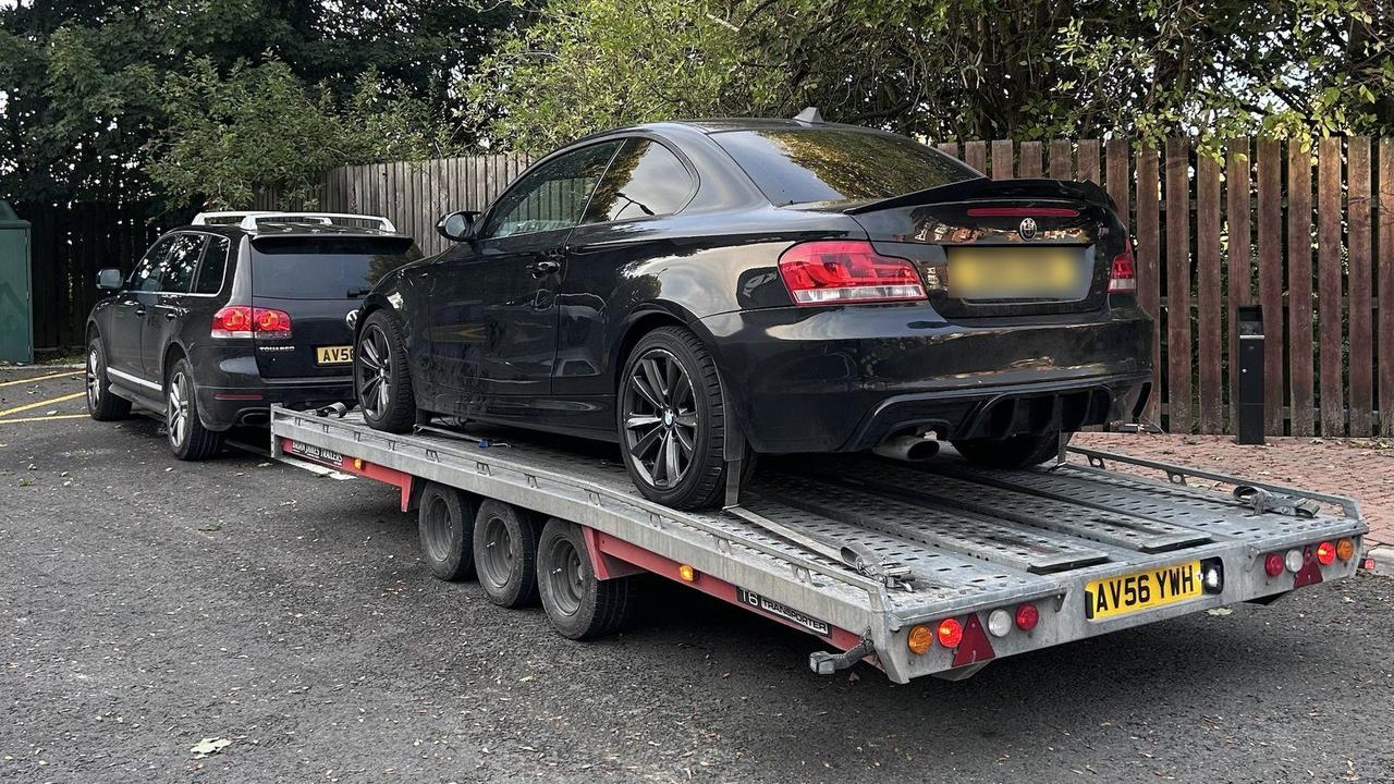 Black BMW 1 Series strapped down on the trailer